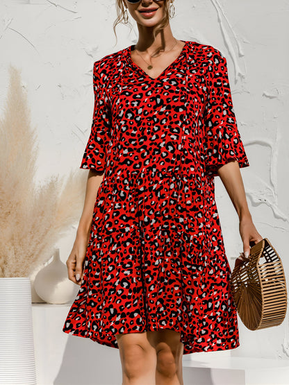 Red - Woman wearing a lightweight leopard print mini dress with flutter sleeves, a tie neckline, and a tiered skirt.