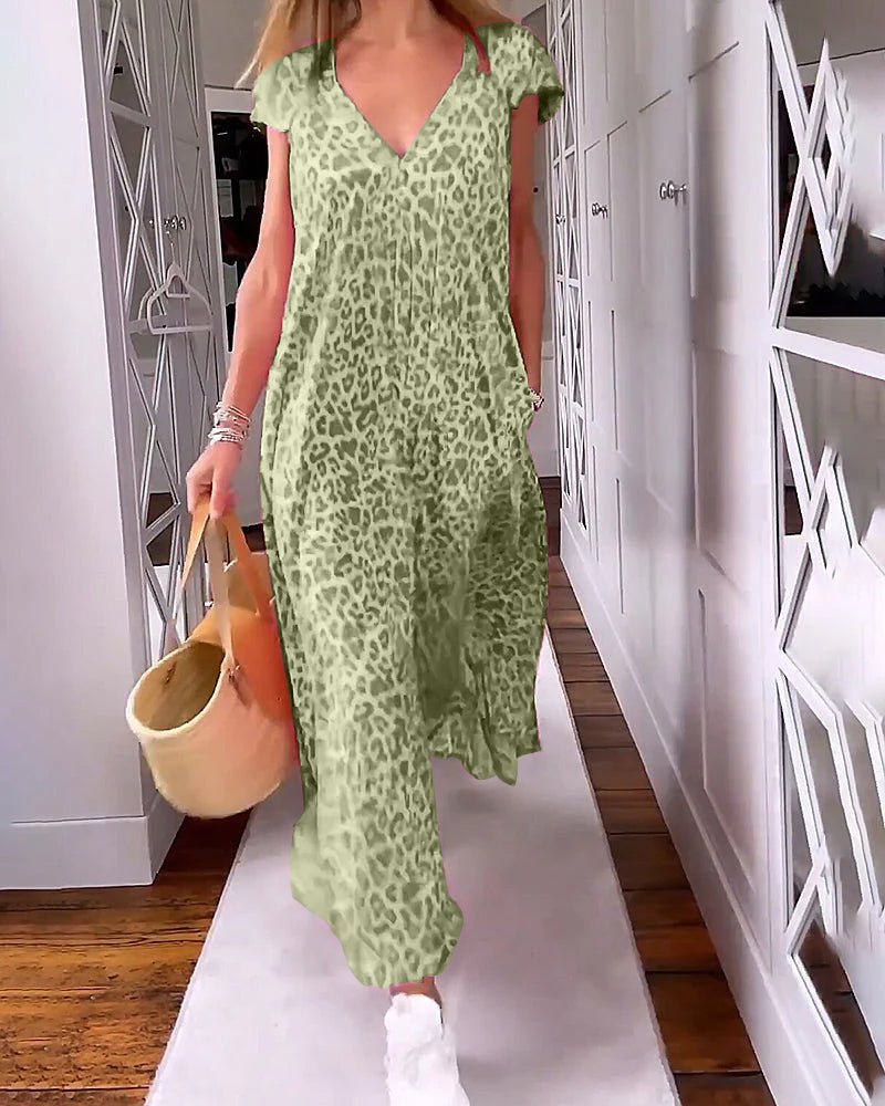 Dark Green - A woman walks down a hallway wearing a pink leopard print maxi dress with a V-neckline and cap sleeves, carrying a woven straw tote bag.