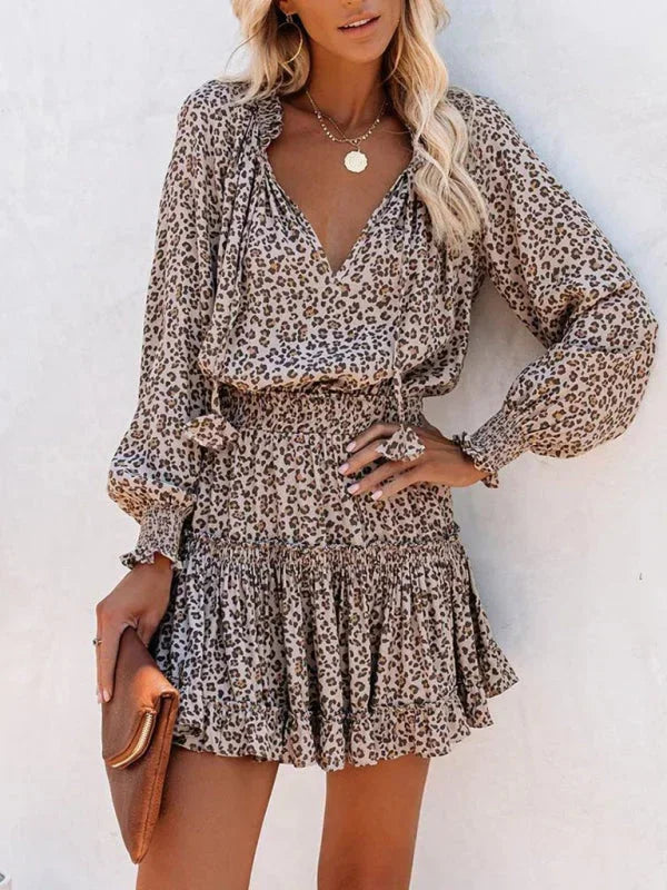 leopard - Leopard print long-sleeve mini dress featuring a V-neckline with tassel ties, a wide smocked waist, and a tiered ruffle skirt.
