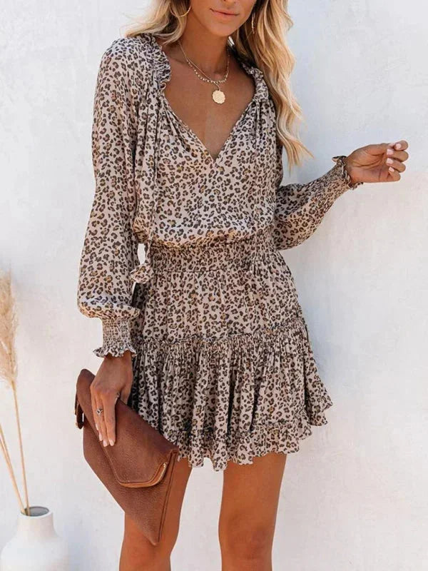 leopard - Leopard print long-sleeve mini dress featuring a V-neckline with tassel ties, a wide smocked waist, and a tiered ruffle skirt.