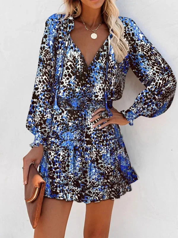 Blue - Leopard print long-sleeve mini dress featuring a V-neckline with tassel ties, a wide smocked waist, and a tiered ruffle skirt.