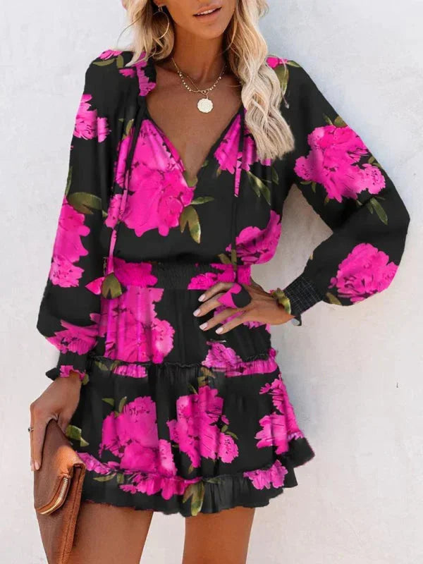 rose - Leopard print long-sleeve mini dress featuring a V-neckline with tassel ties, a wide smocked waist, and a tiered ruffle skirt.