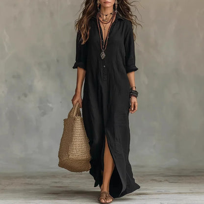 Black - A woman wearing a white textured linen maxi shirt dress with rolled sleeves, a partial button placket, and a front split, carrying a woven straw tote bag.