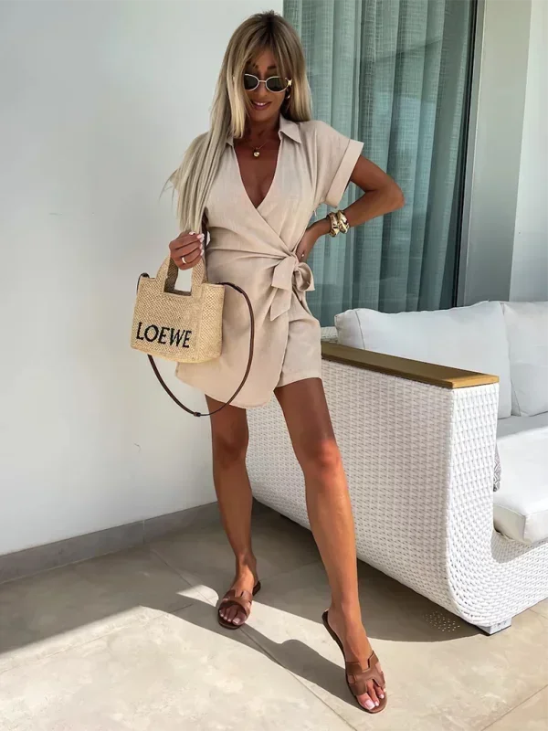 Khaki - Woman wearing a rust-colored linen-blend mini dress with a collar, deep V-neck, and tie waist, styled with sandals and a straw bag.