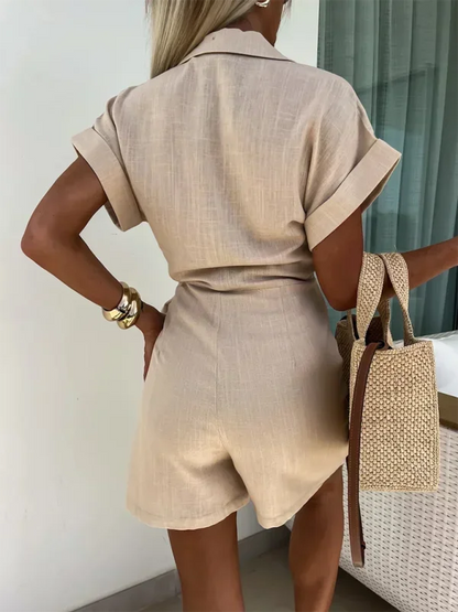 Khaki - Woman wearing a rust-colored linen-blend mini dress with a collar, deep V-neck, and tie waist, styled with sandals and a straw bag.