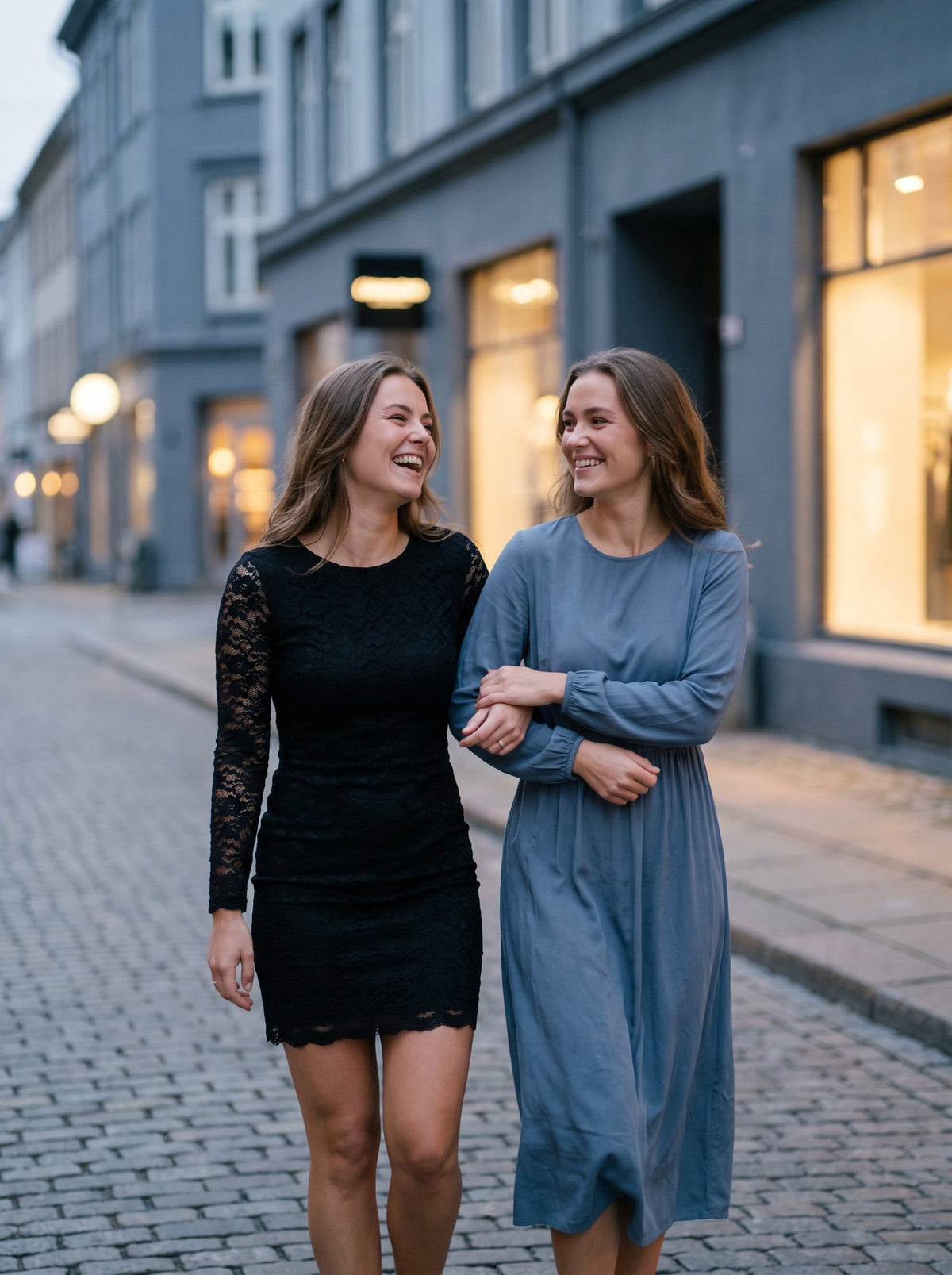 Two friends in a black lace dress and a blue midi dress