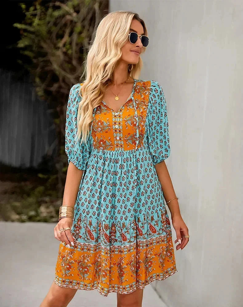 Blue - Light blue and mustard orange mixed floral print dress featuring a split v-neckline with ties, half puff sleeves, and a tiered skirt.