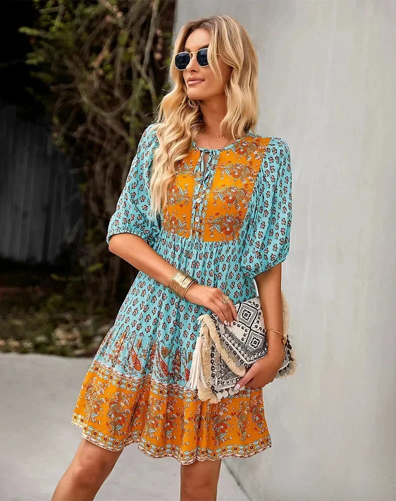 Blue - Light blue and mustard orange mixed floral print dress featuring a split v-neckline with ties, half puff sleeves, and a tiered skirt.