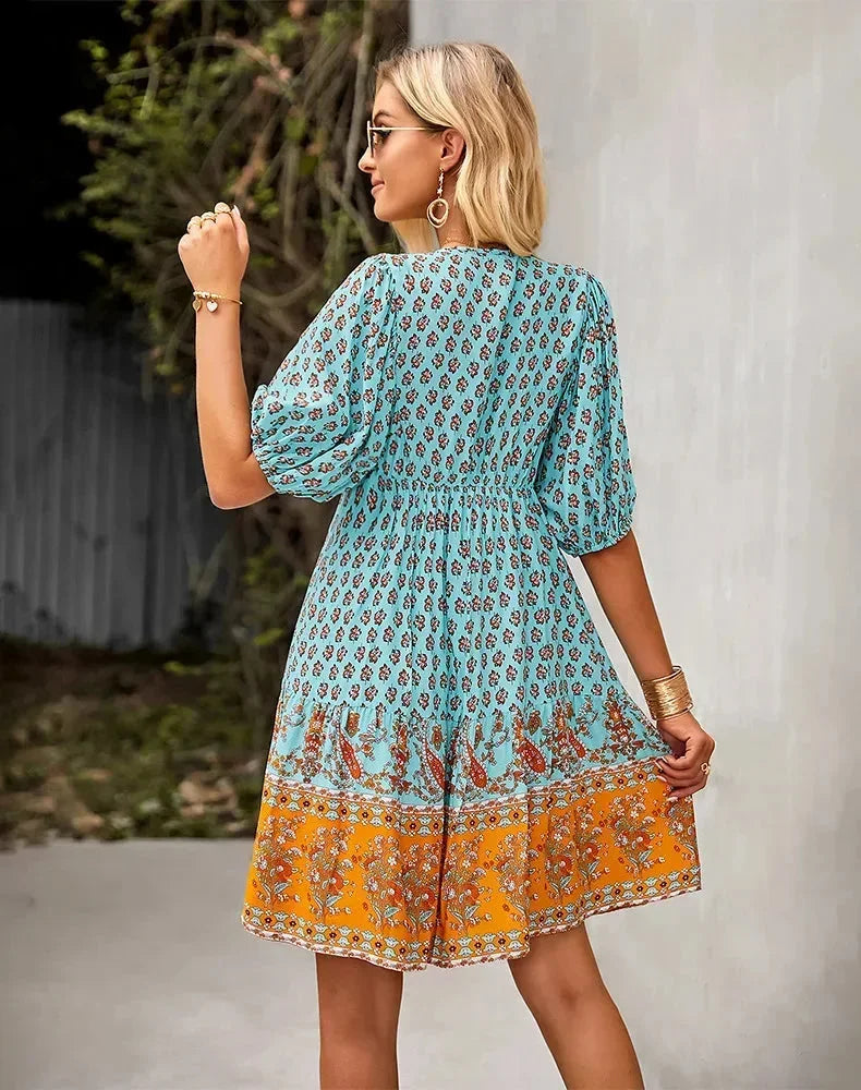 Blue - Light blue and mustard orange mixed floral print dress featuring a split v-neckline with ties, half puff sleeves, and a tiered skirt.