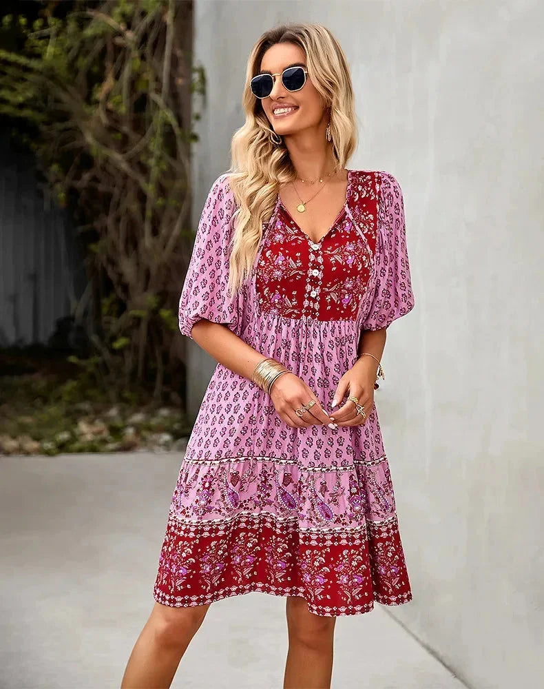 Pink - Light blue and mustard orange mixed floral print dress featuring a split v-neckline with ties, half puff sleeves, and a tiered skirt.