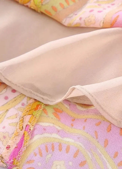 Yellow - Woman wearing a bright pink and yellow paisley print mini dress with long split sleeves, a deep V-neck, and waist cutouts.