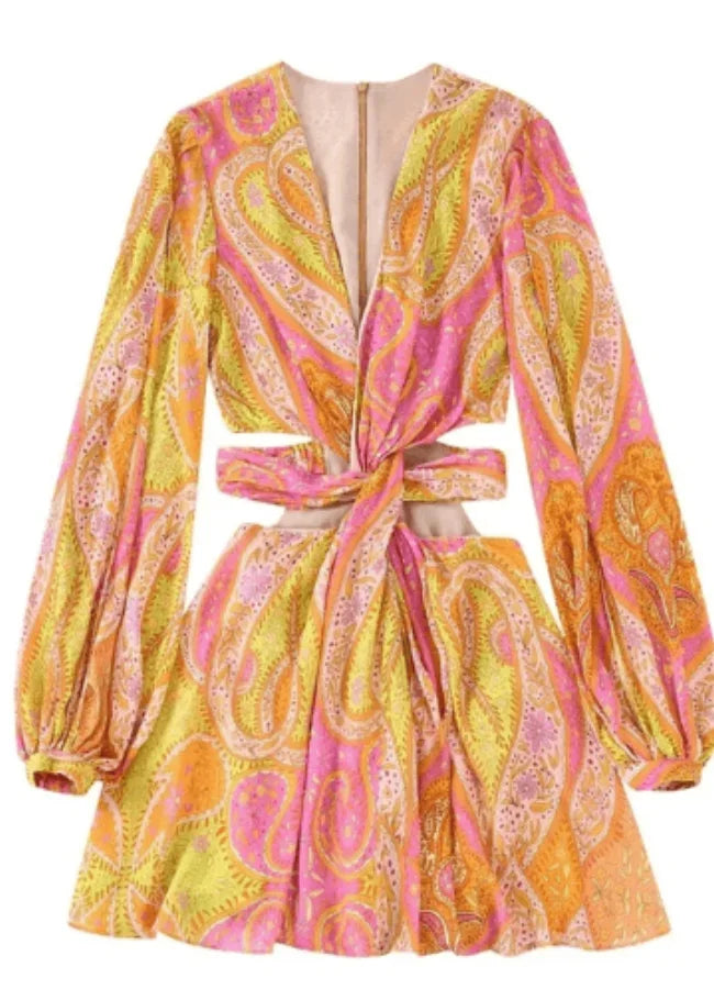 Yellow - Woman wearing a bright pink and yellow paisley print mini dress with long split sleeves, a deep V-neck, and waist cutouts.