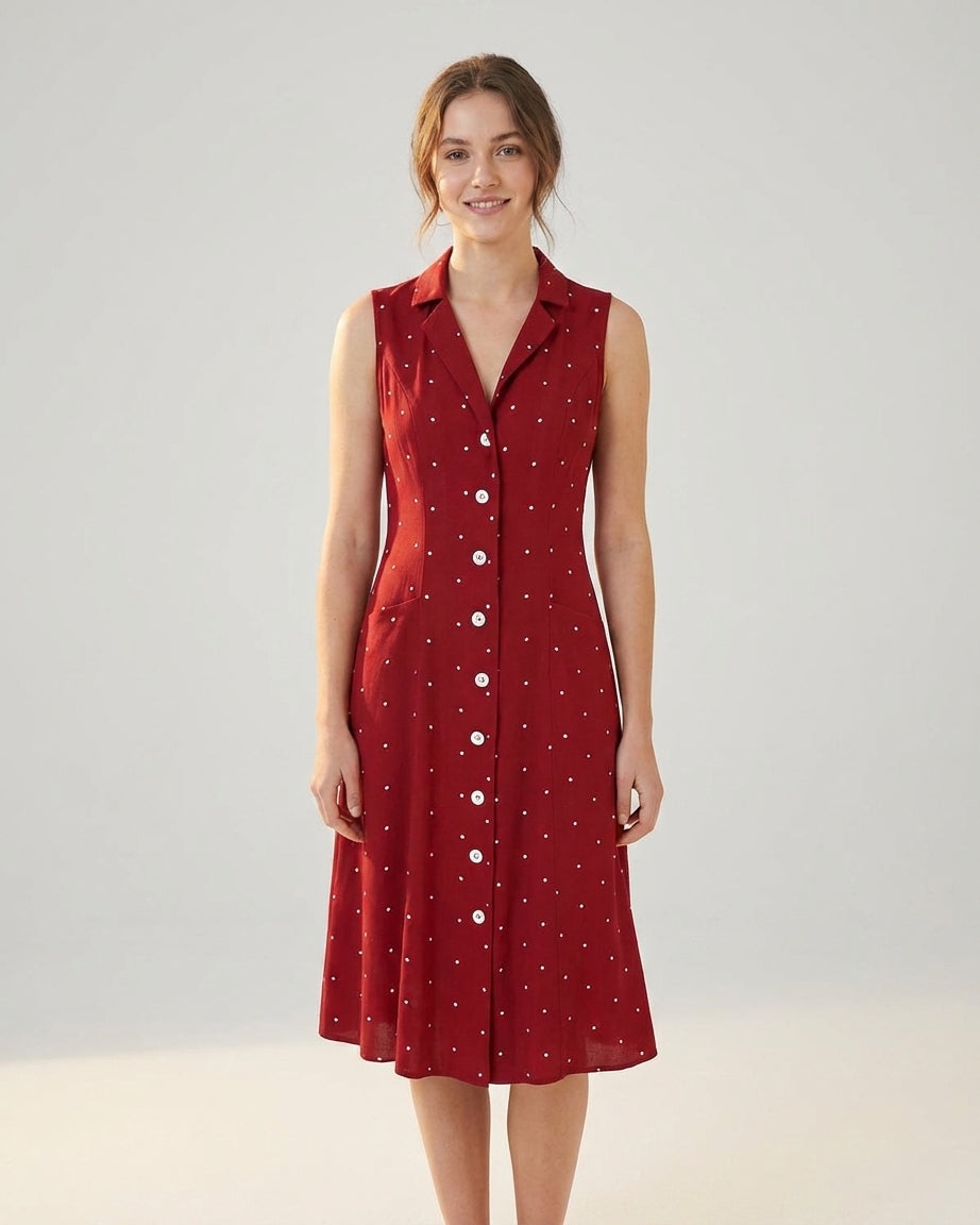 Red - A woman wearing a sleeveless dark red midi dress with white pin dots, featuring a notched collar, button-down front, and side pockets.