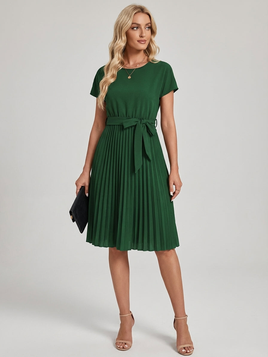 Green - A woman wearing a short-sleeve, crew-neck burgundy midi dress with a belted waist and a pleated accordion skirt, holding a black clutch.