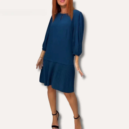 Solid dark teal drop-waist midi dress featuring a keyhole neckline, three-quarter balloon sleeves, and a sharply pleated skirt.