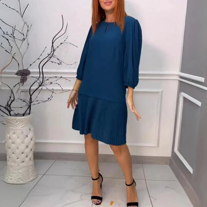 Blue - Solid dark teal drop-waist midi dress featuring a keyhole neckline, three-quarter balloon sleeves, and a sharply pleated skirt.