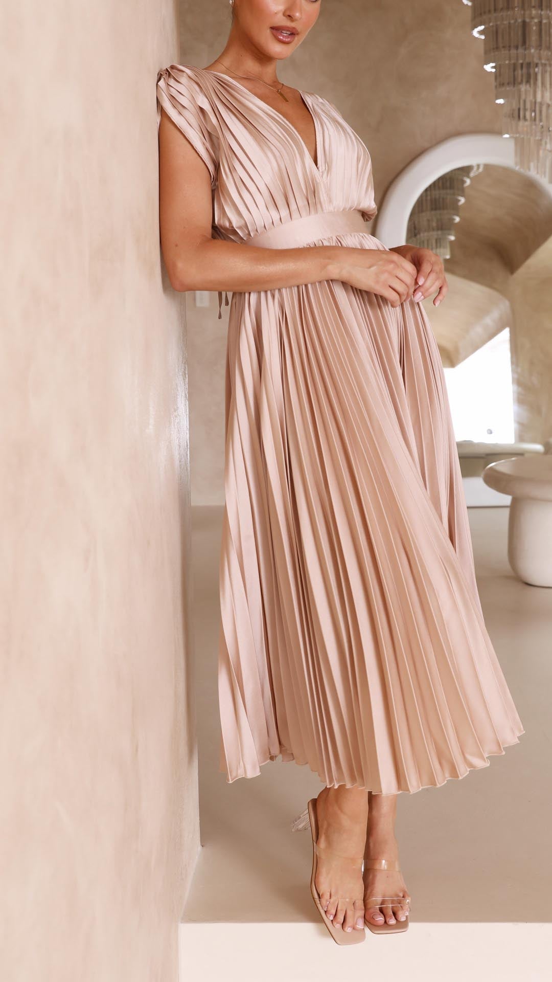 Antique Pink - Woman wearing a dusty rose pleated midi dress with a deep V-neckline and banded waist.