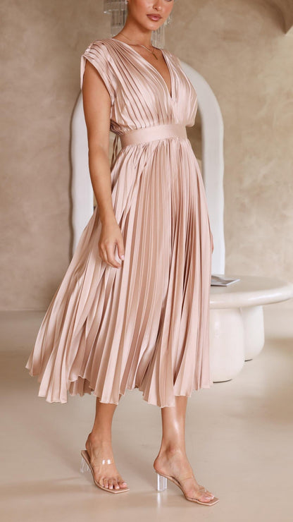 Antique Pink - Woman wearing a dusty rose pleated midi dress with a deep V-neckline and banded waist.