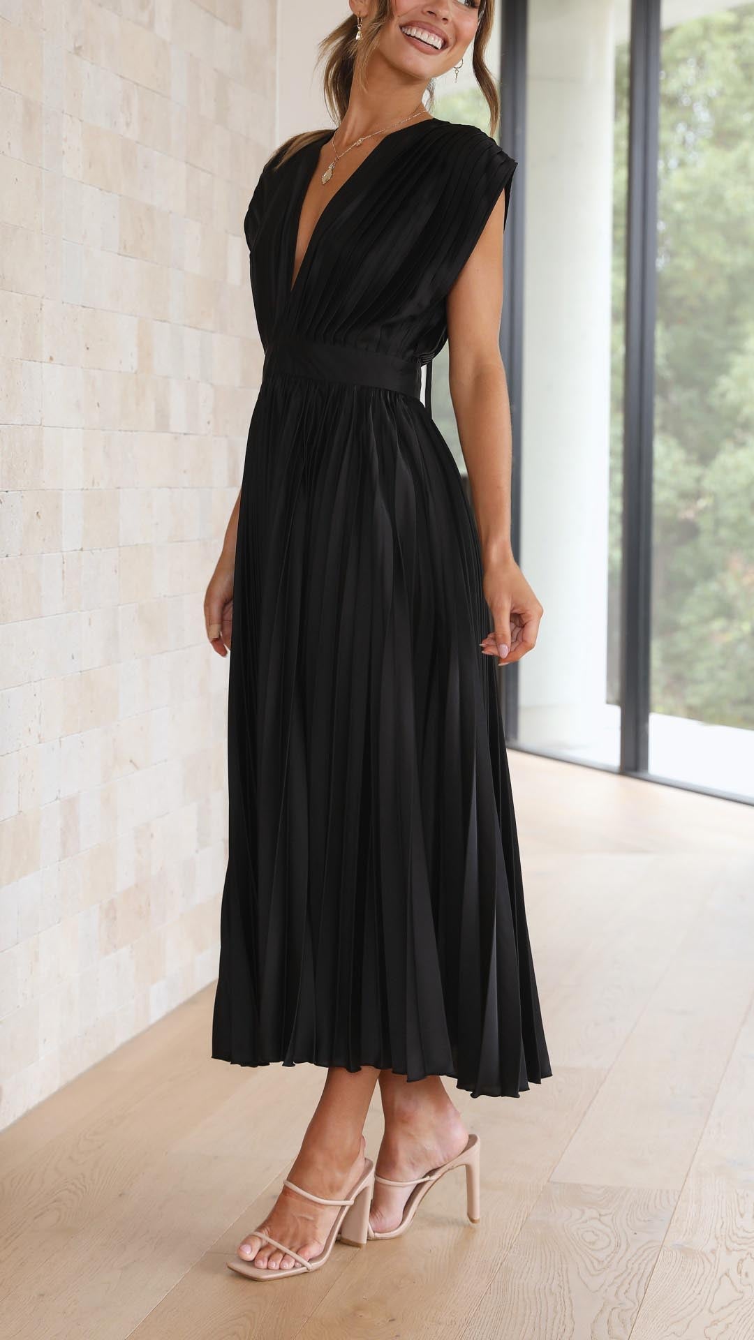 Antique Pink - Woman wearing a dusty rose pleated midi dress with a deep V-neckline and banded waist.