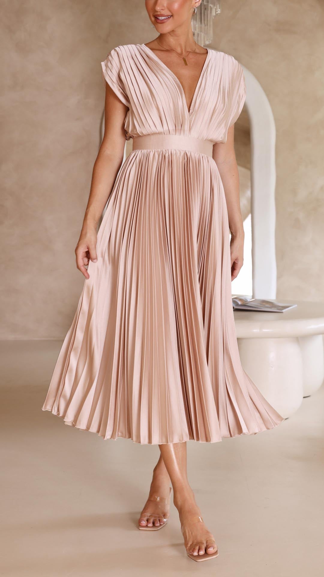 Champagne - Woman wearing a dusty rose pleated midi dress with a deep V-neckline and banded waist.