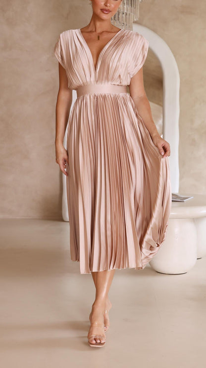 Antique Pink - Woman wearing a dusty rose pleated midi dress with a deep V-neckline and banded waist.