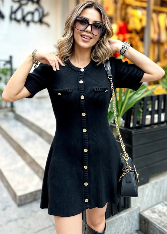 Black ribbed knit short-sleeve mini dress featuring a metallic button-front closure, crew neckline, and chest flap pockets.