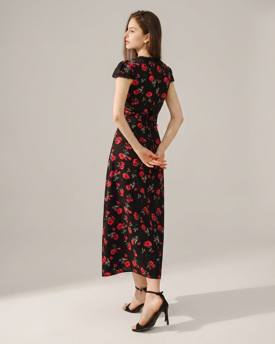Black - A woman wearing a black midi-length dress with a red rose print, featuring a lace-trimmed V-neckline, cap sleeves, and a fluid A-line skirt.