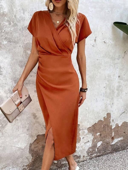 Orange - Woman wearing a burnt orange midi dress with a wrap v-neckline, side ruching, and an asymmetrical front slit.
