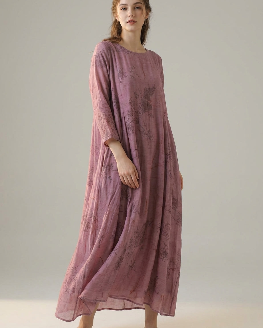 Purple - A woman wearing a dusty purple midi dress with a dark abstract floral print, featuring adjustable tie straps, a ruffled V-neckline, and a sheer chiffon hem.