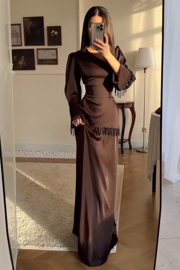 Brown - Woman wearing a chocolate brown satin long sleeve maxi dress with beaded fringe detailing at the cuffs and waistline.