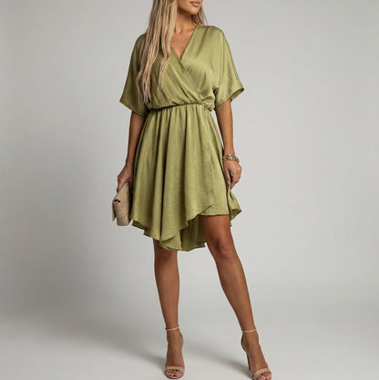 Khaki - A woman wearing a light olive green satin mini dress featuring a deep V-neck, twist-front waist detail, short flutter sleeves, and a tiered asymmetric skirt, paired with nude heeled sandals.
