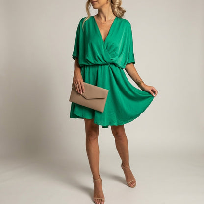 Dark Green - A woman wearing a light olive green satin mini dress featuring a deep V-neck, twist-front waist detail, short flutter sleeves, and a tiered asymmetric skirt, paired with nude heeled sandals.
