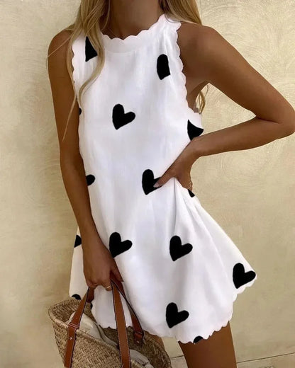 Heart - White sleeveless mini dress featuring a black heart print, high neckline, and scalloped edges along the armholes and hem.