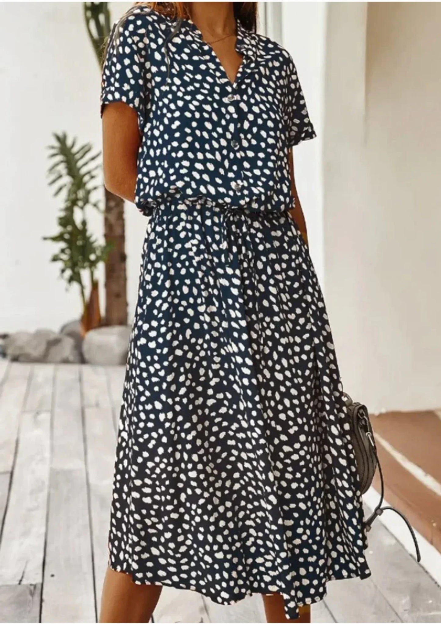 Deep Blue - Woman wearing a white midi shirt dress with a brown abstract spotted print, featuring a collared button-front bodice and a drawstring waist.