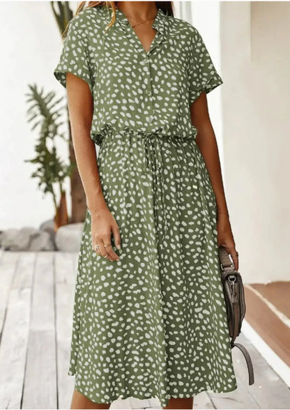 Khaki - Woman wearing a white midi shirt dress with a brown abstract spotted print, featuring a collared button-front bodice and a drawstring waist.
