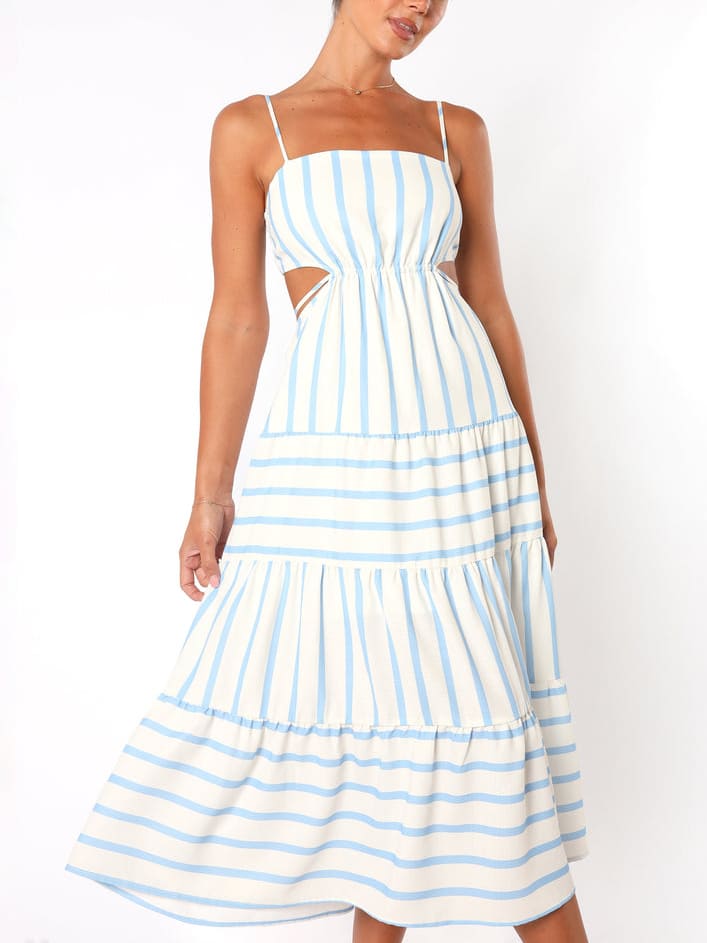 A woman wearing a light blue and white striped midi dress featuring a square neckline, thin spaghetti straps, side waist cutouts, and a tiered skirt with alternating stripe directions.