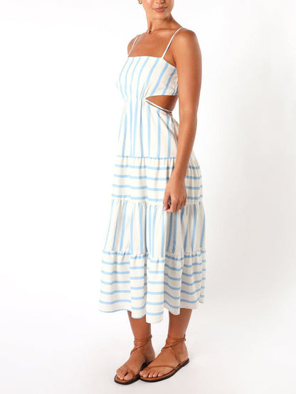 A woman wearing a light blue and white striped midi dress featuring a square neckline, thin spaghetti straps, side waist cutouts, and a tiered skirt with alternating stripe directions.