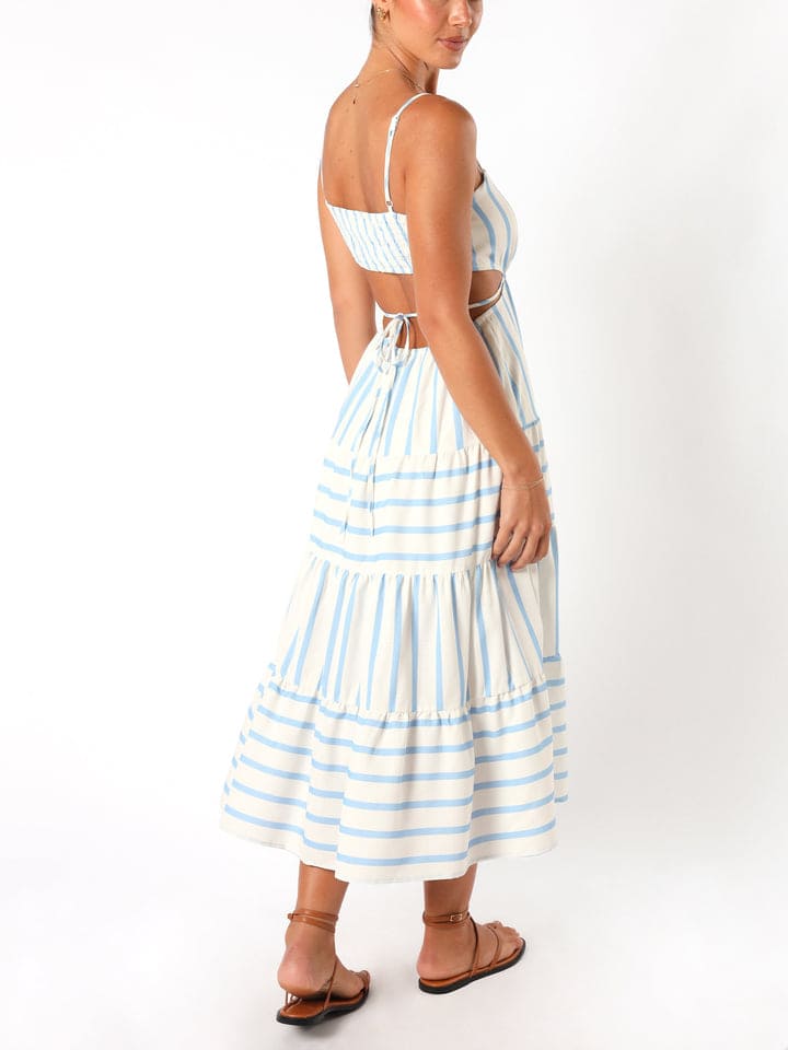 A woman wearing a light blue and white striped midi dress featuring a square neckline, thin spaghetti straps, side waist cutouts, and a tiered skirt with alternating stripe directions.