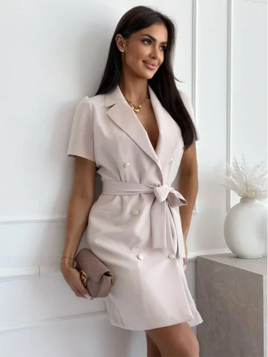 Light beige short-sleeve blazer dress featuring a notched lapel, double-breasted button front, and a cinched self-tie waist belt.