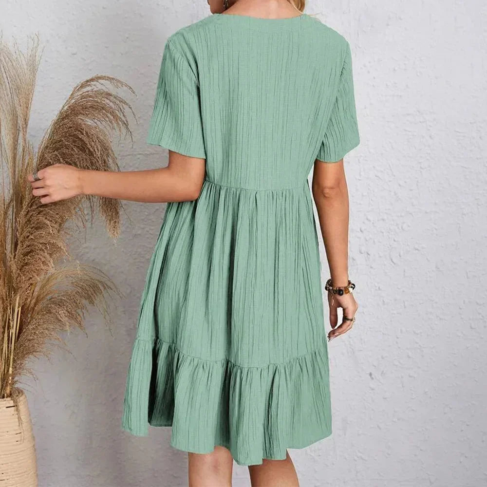 Black - Light green textured crepe mini dress featuring a V-neckline, short sleeves, and a tiered babydoll silhouette.