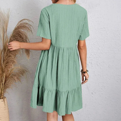 Black - Light green textured crepe mini dress featuring a V-neckline, short sleeves, and a tiered babydoll silhouette.