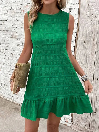 Sleeveless shift mini dress featuring allover horizontal texturing, a high neckline, and a dropped flounce hem.