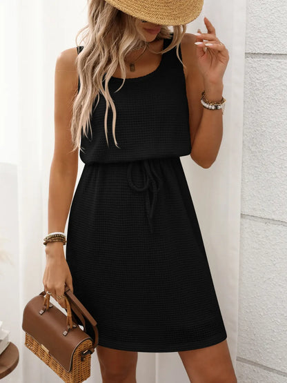Black - Sleeveless textured knit mini dress featuring a scoop neckline and an adjustable drawstring waist.