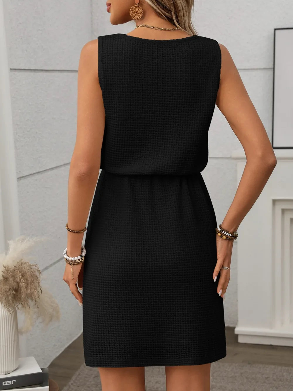 Black - Sleeveless textured knit mini dress featuring a scoop neckline and an adjustable drawstring waist.