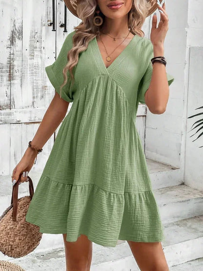 Green - Light beige textured linen mini dress featuring a V-neckline, cuffed short sleeves, and a tiered ruffled hem.
