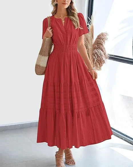 Red - A woman wearing a dusty pink, textured stripe maxi dress featuring a smocked waist, tiered skirt, short sleeves, and a split neckline, styled with a woven straw shoulder bag.
