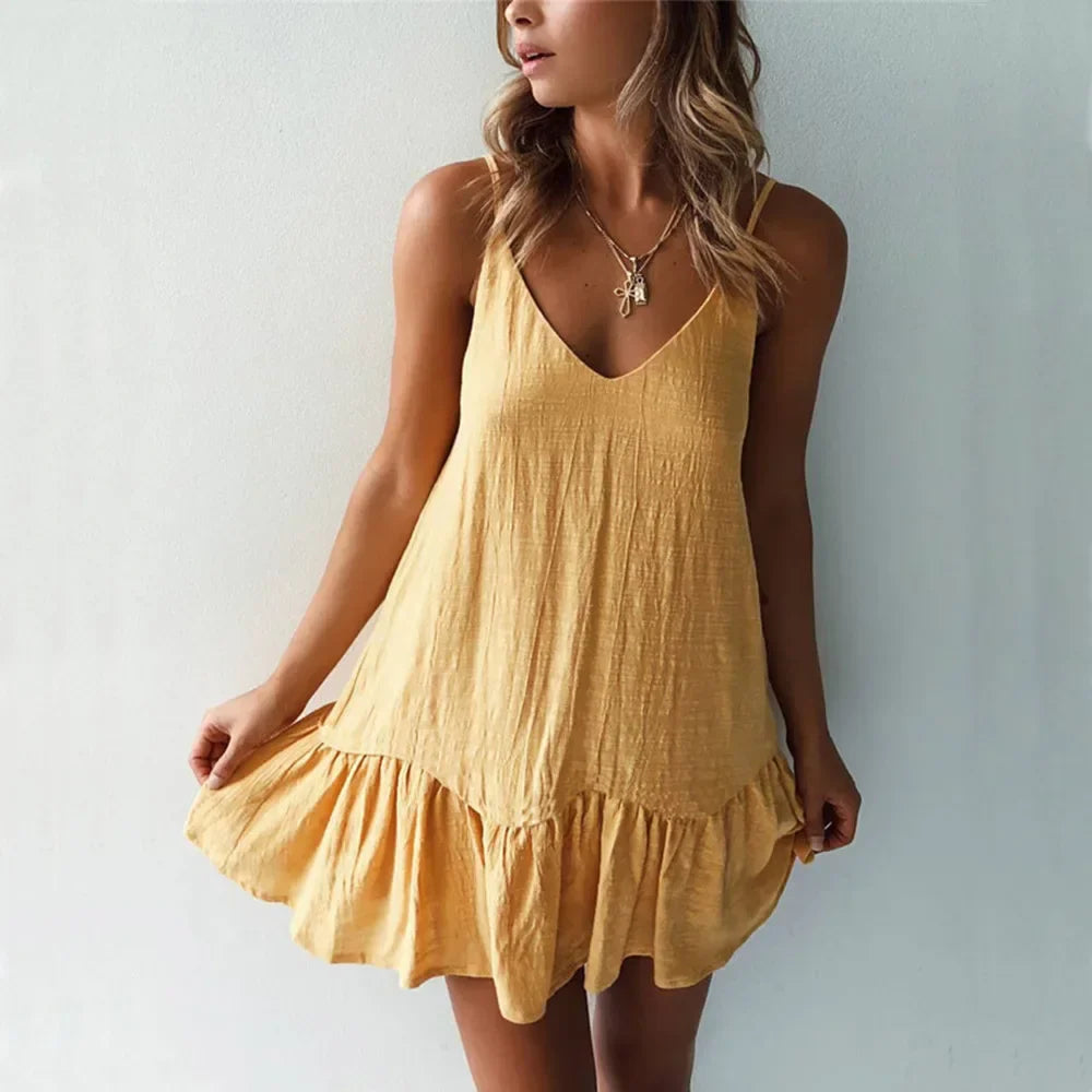 Yellow - A woman wearing a sleeveless, mustard-yellow mini dress with a textured crinkle fabric, V-neckline, thin spaghetti straps, and a ruffled hem.