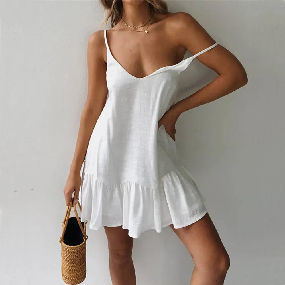 White - A woman wearing a sleeveless, mustard-yellow mini dress with a textured crinkle fabric, V-neckline, thin spaghetti straps, and a ruffled hem.