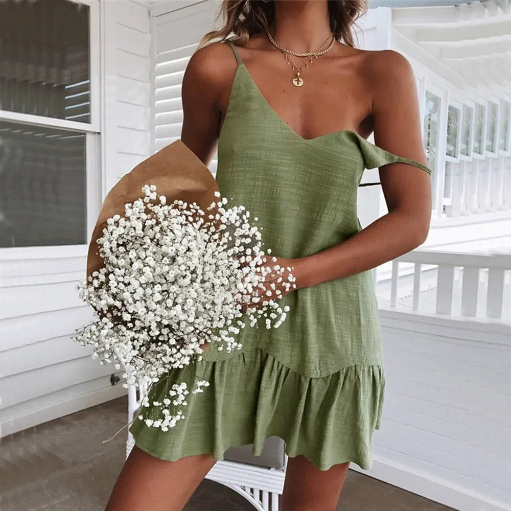 Green - A woman wearing a sleeveless, mustard-yellow mini dress with a textured crinkle fabric, V-neckline, thin spaghetti straps, and a ruffled hem.