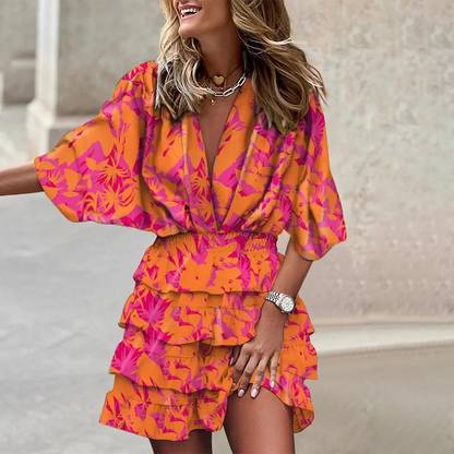 Orange - Black and beige tropical leaf print mini dress featuring a deep V-neckline, wide sleeves, smocked waist, and tiered ruffle skirt.